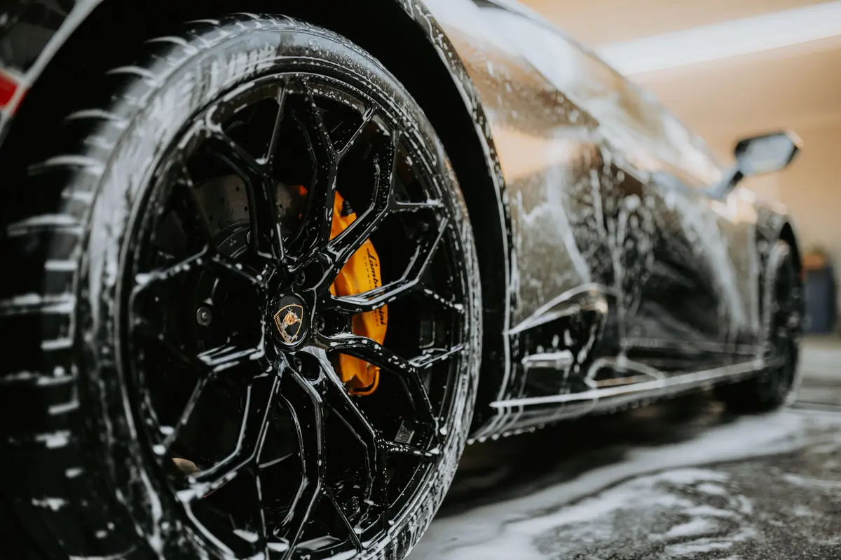 Alloy wheel covered in cleaning foam
