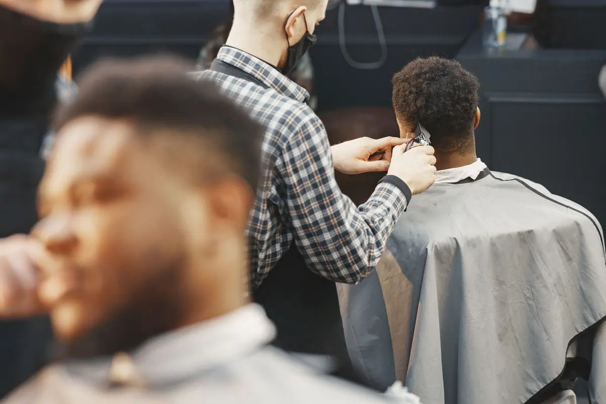 Barber blending a skin fade with clippers