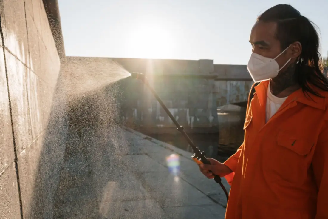 Pressure washing a sunlit wall